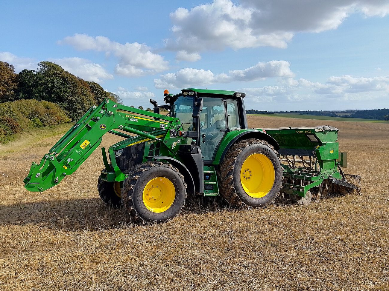Green tractor with front loader in a field